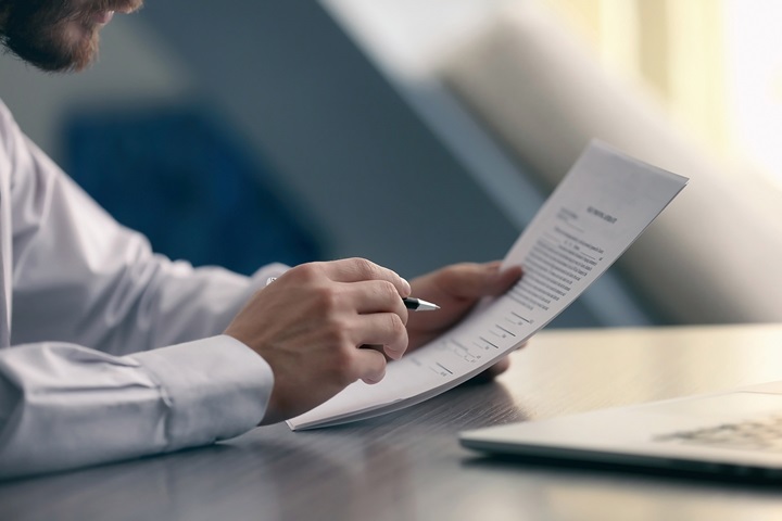 Close up of hands holding documents and pen